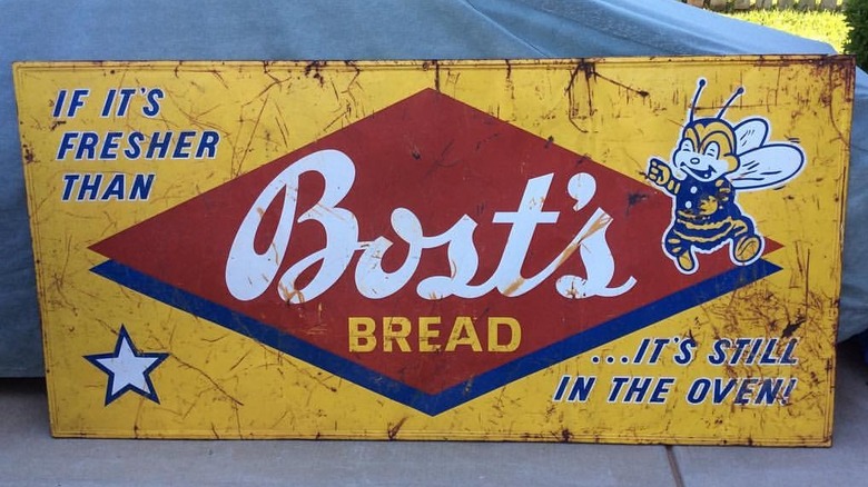 A beaten-up metal sign for Bost's Bread