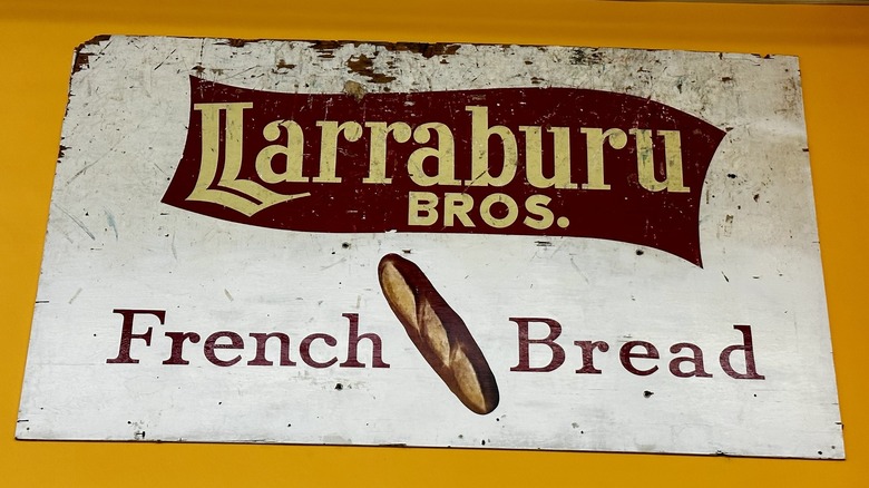 A wall sign advertising Larraburu Bros. French Bread on a yellow/orange wall