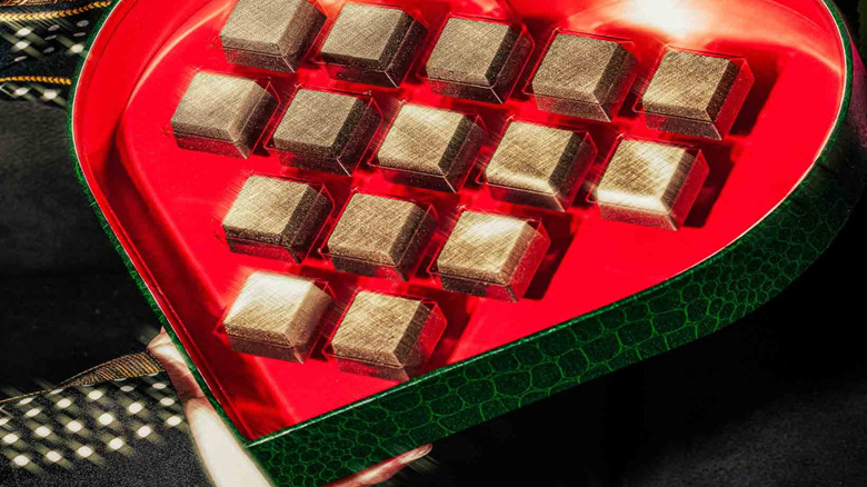 A close-up of Compartés' 24-karat gold square chocolates in a heart-shaped box