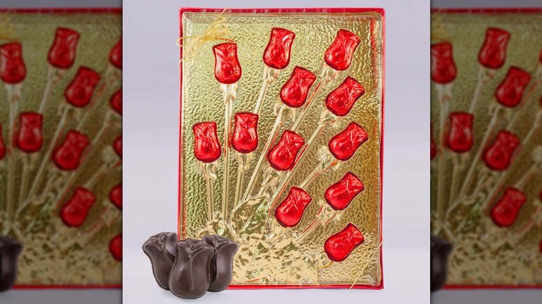 A set of 12 red foil-wrapped chocolate roses in a gold box