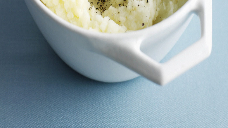 seasoning mashed potatoes in bowl