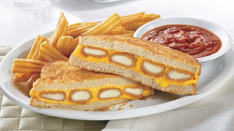 a close up of Denny's fried cheese melt with fries and marinara sauce