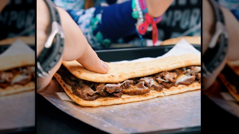 A close-up of someone handline a Taco Bell triple steak stack