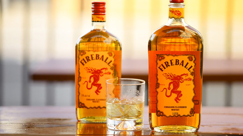 Two bottles of Fireball whisky sit on a tabletop