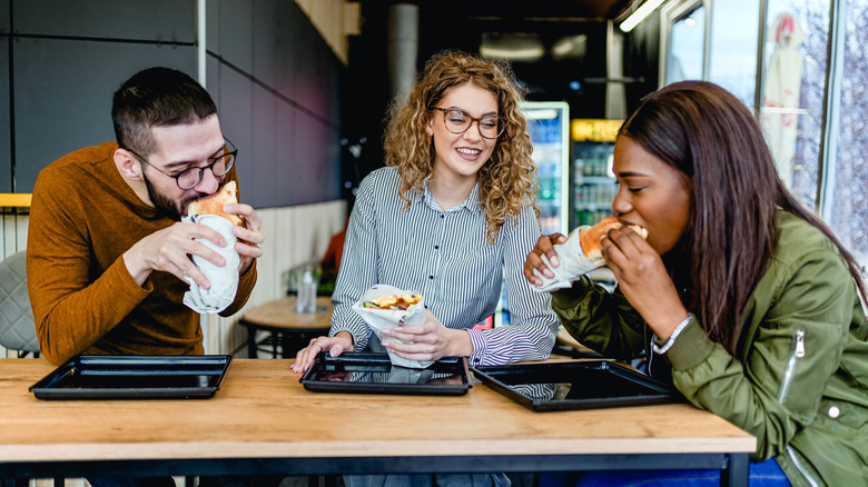 three people eating at a restaurant