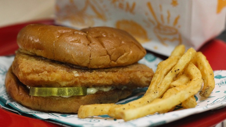 Popeyes' fish sandwich with fries on table