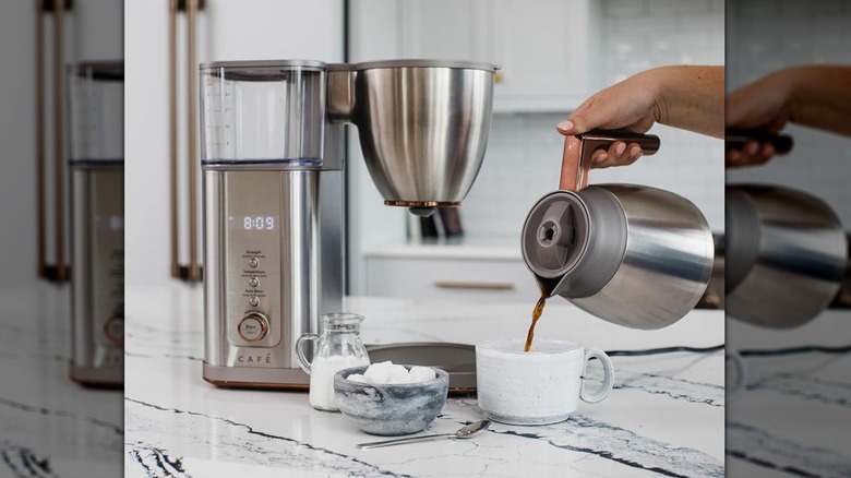 A person pouring coffee from a  Café Specialty coffee maker