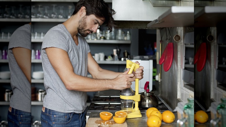 A man using an orange juicer