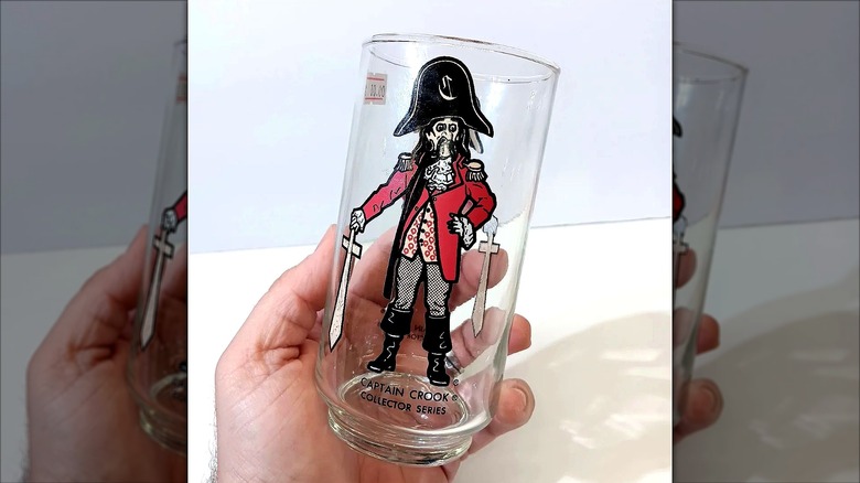 Captain Crook print on a glass being held by a hand