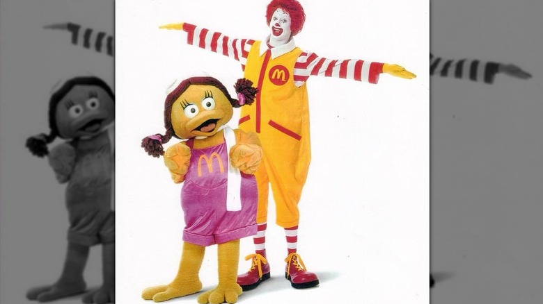 Ronald McDonald flying with arms stretched out over Birdie