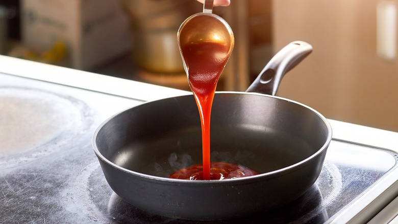 pouring ketchup into pan