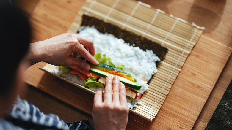 Person rolling up a sushi roll