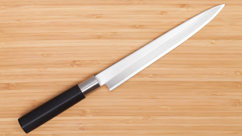 A sushi knife on a wooden board