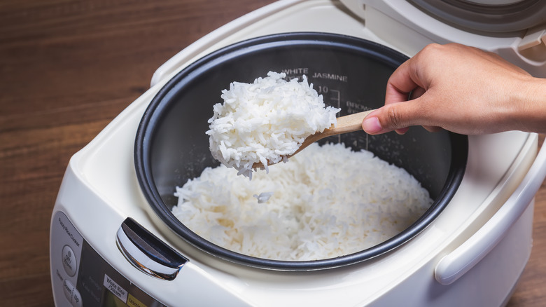 Person making rice in a rice cooker