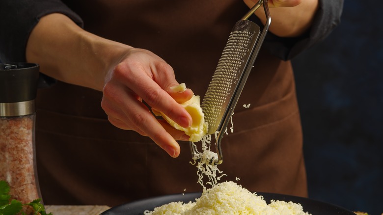grating cheese over plate