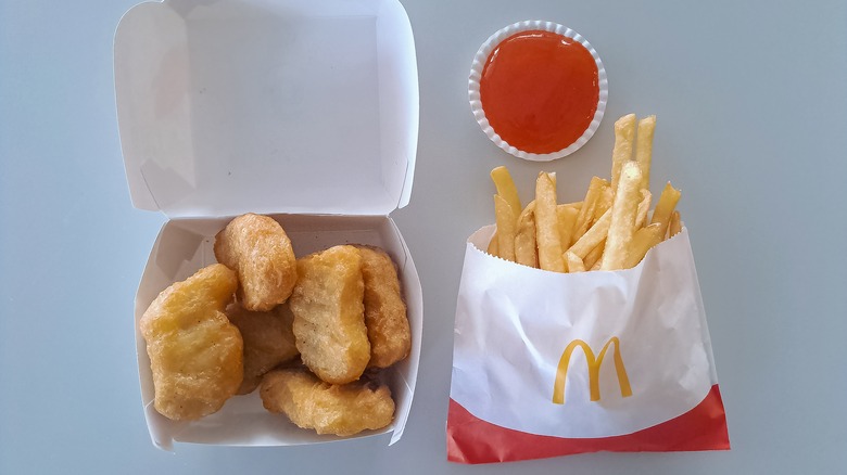 open container of mcdonald's mcnuggets next to fries