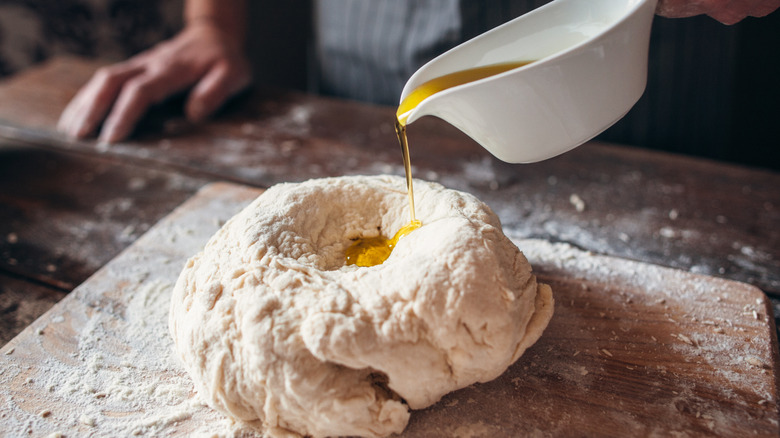 Oil being added to fresh bread dough