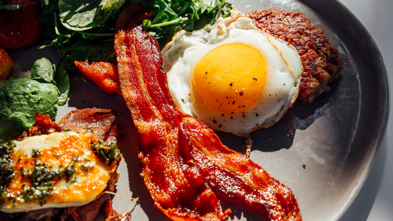 A plate of bacon, egg, and sausage.