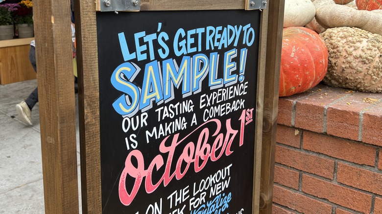 chalkboard sign outside Trader Joe's reading, "Let's get ready to sample!"