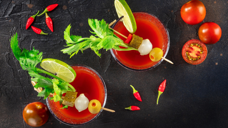 Bloody Mary garnished with lime, celery, olives, pearl onions, and tomatoes