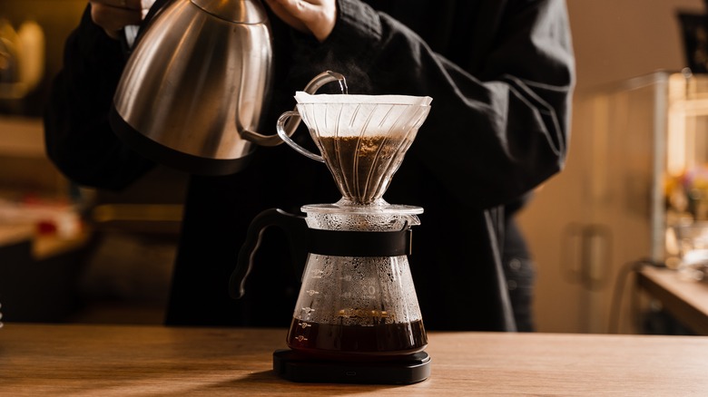 Gooseneck kettle pouring water into V60 coffee maker