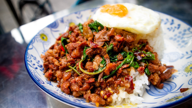 Holy basil chicken served with rice and a fried egg.