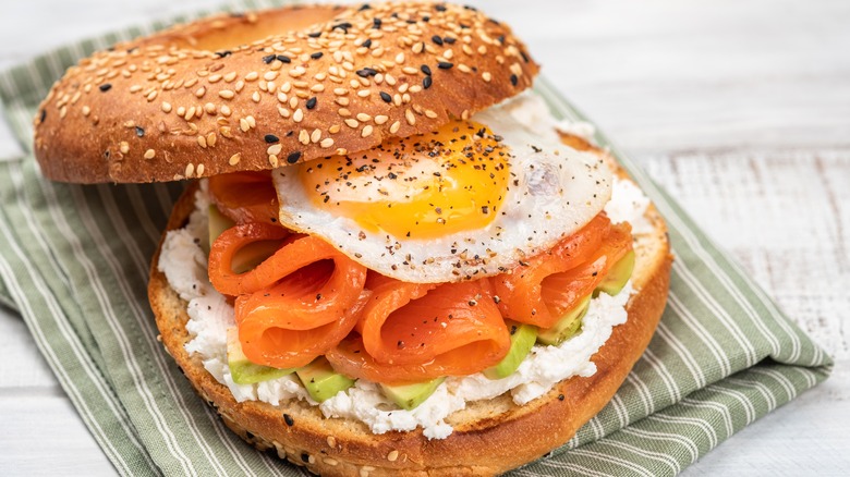 Bagel sandwich with egg, avocado, salmon, and cream cheese