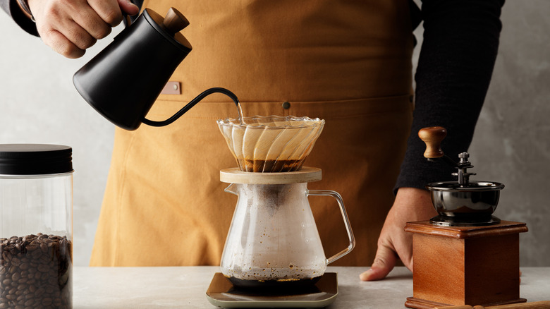 Person pouring water into top of coffee maker