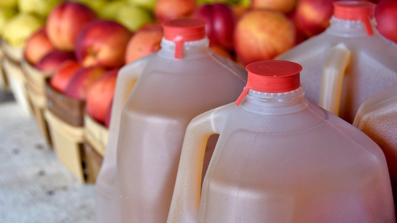 Jugs of apple cider and apples