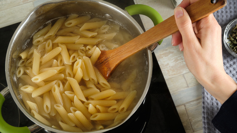 Penne pasta cooking in a pot.