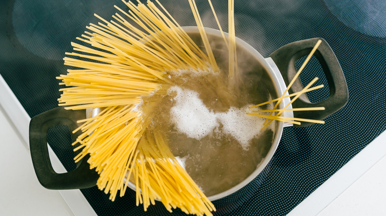 Spaghetti boiling in a pot.