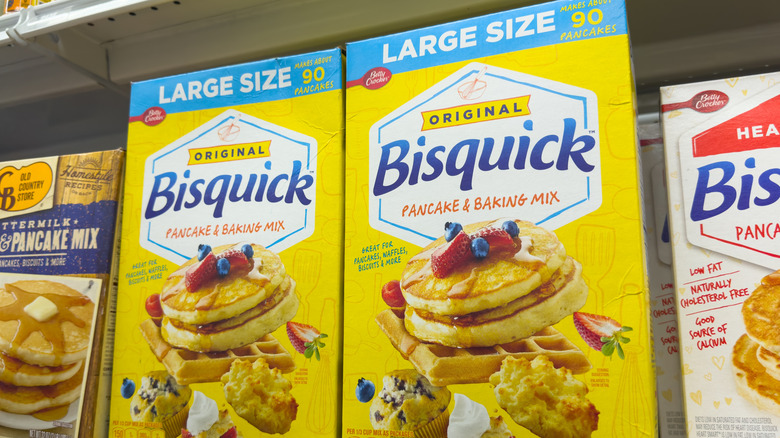 Several boxes of Bisquick pancake mix on grocery shelf.