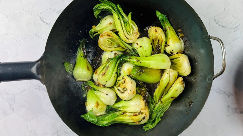 cooked bok choy in a black wok