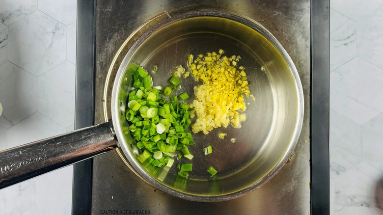 green onions, garlic, and ginger in a frying pan