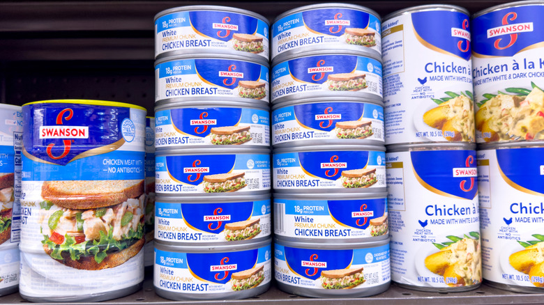 Cans of chicken products on grocery shelf