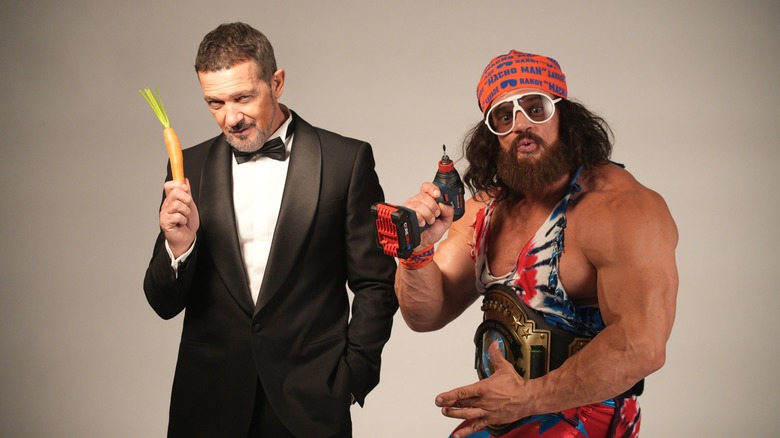 Antonio Banderas in suit with carrot in hand next to Macho Man lookalike holding a power drill