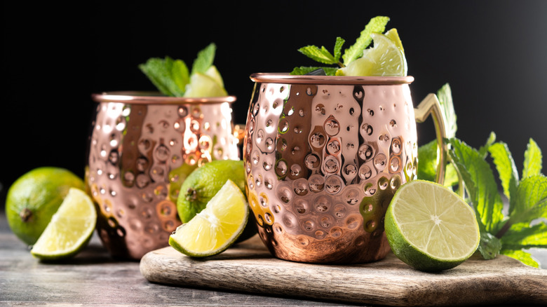 Two copper Moscow Mule cups with lime garnishes