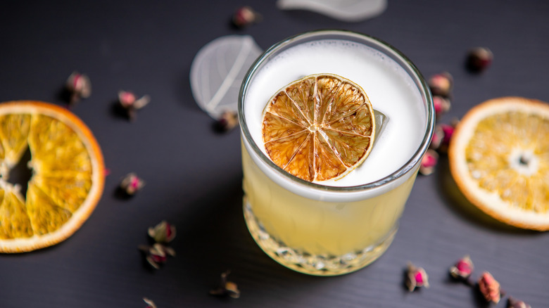 A gimlet with a lime wedge on a black table