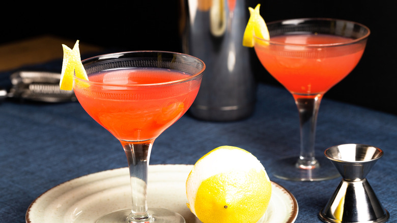 Two Paper Plane cocktails on a table with a lemon