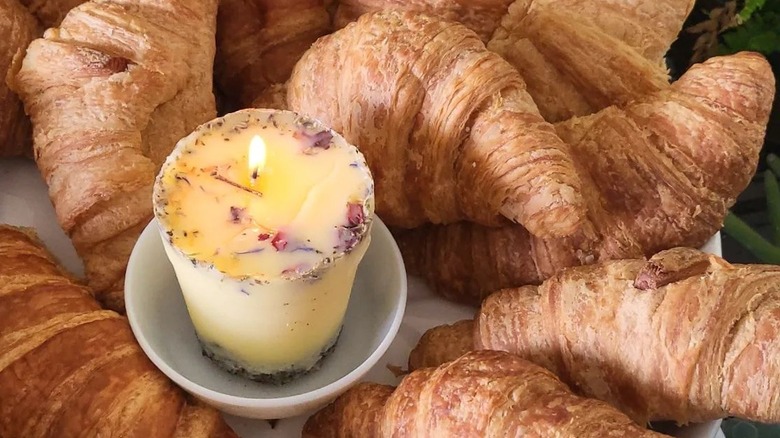 butter candle in a dish surrounded by croissants