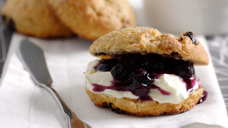 Scone split with blueberries and crème fraîche inside.