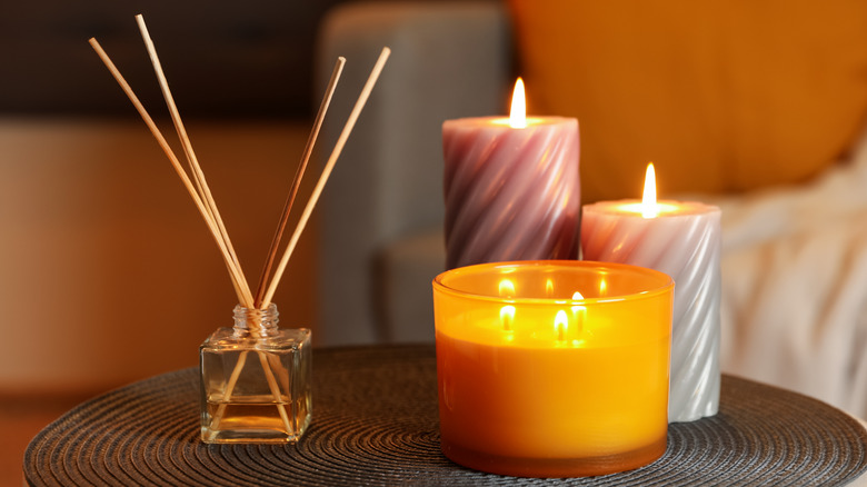 a perfume diffuser and scented candles on a table