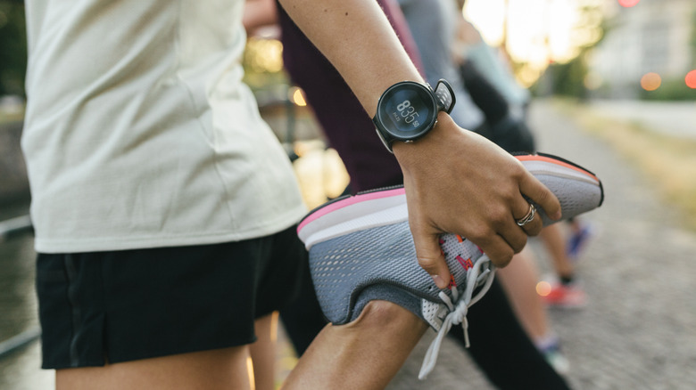 A close up of a woman stretching her legs before going on a run through the city