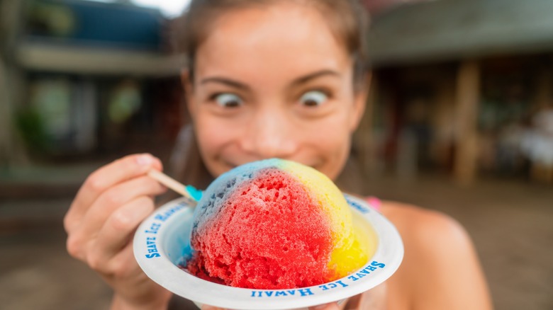 Girl eating multicolored shaved ice in a bowl