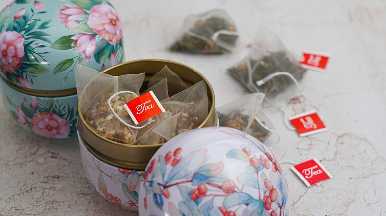 Tea bags stored in ornate floral jars