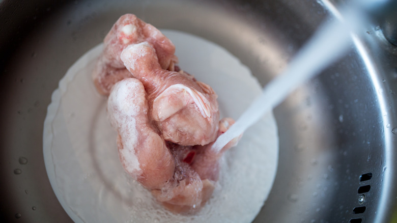 Chicken defrosting in running water