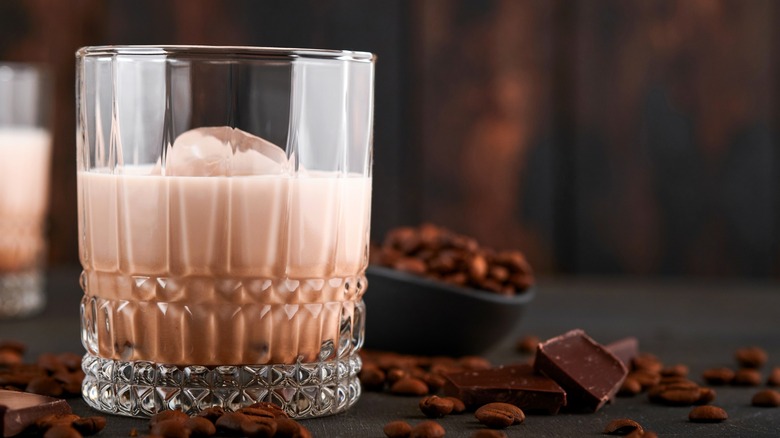 Baileys Irish Cream in rocks glass with chocolate and coffee beans around