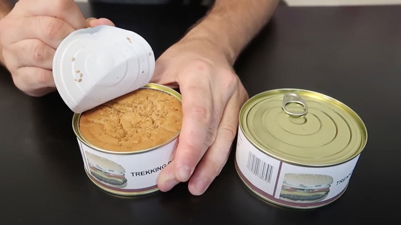 Man opening "Trekking Burger" canned cheeseburger