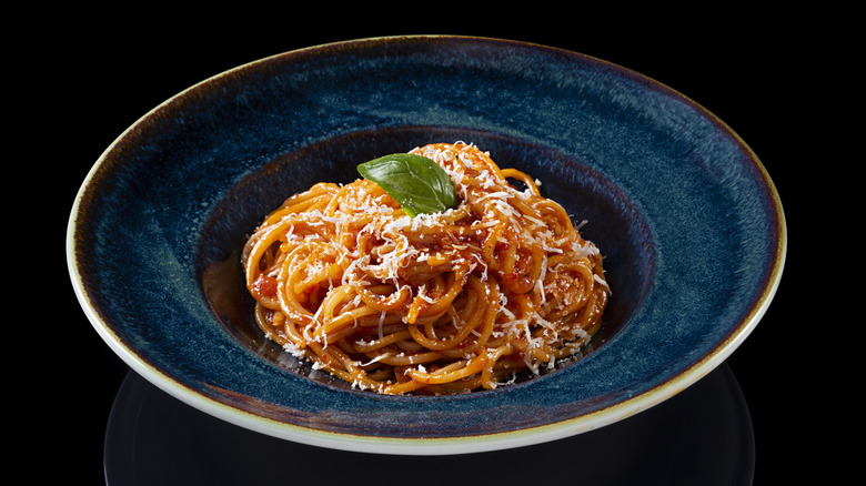 spaghetti in bowl with basil