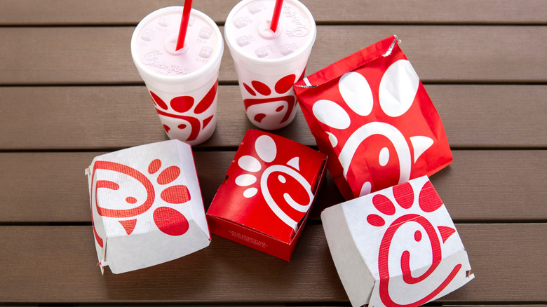 Overhead view of Chick-fil-A food in branded packaging on wood slatted surface.